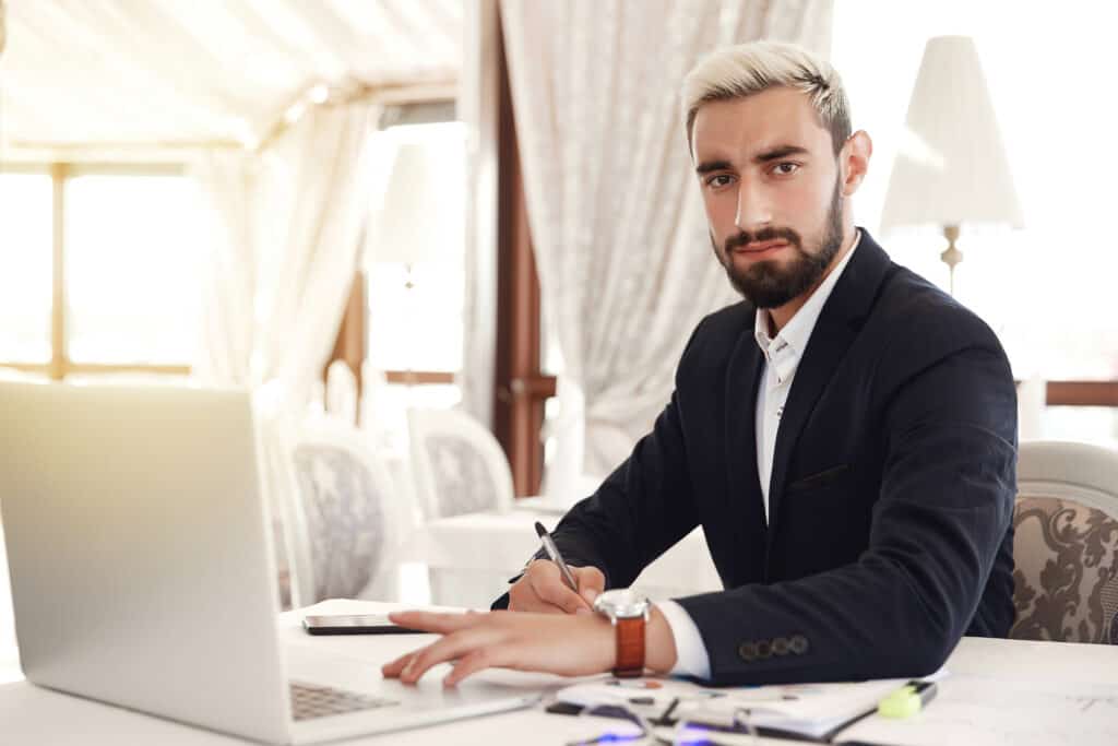 serious boss is looking straight preparing business meeting with laptop restaurant